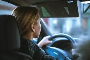 a woman driving a client in a car to a social outing